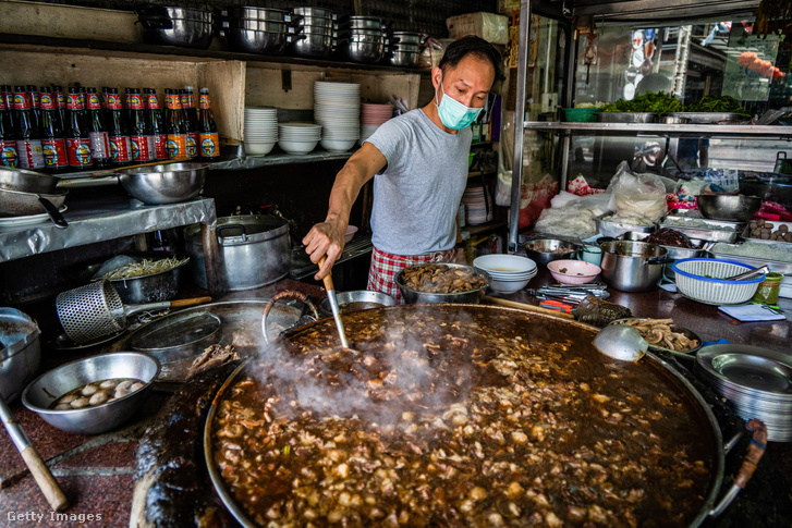 Egy szakács fortyogó marhapörköltet kever a bangkoki StreetSide tésztaboltjában 2022. február 24-én