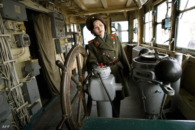 Egyenruhás Észak-koreai kísérő a USS Pueblo kapitányi hídján