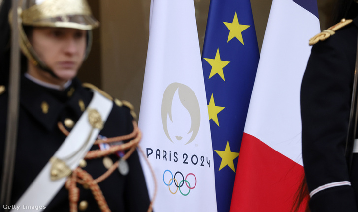 A 2024-es párizsi olimpiai játékok zászlaja a francia nemzeti zászló és az európai zászló mellett az Élysée-palota bejáratánál az európai vezetők és kormányok képviselőinek Ukrajnát támogató konferenciáján, Párizsban, Franciaországban, 2024. február 26-án