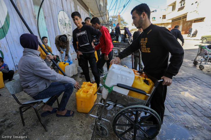 Emberek vizet vételeznek egy víztöltő állomáson 2024. február 29-én a gázai Rafahban, mivel a háború következtében vízhiányban szenvednek