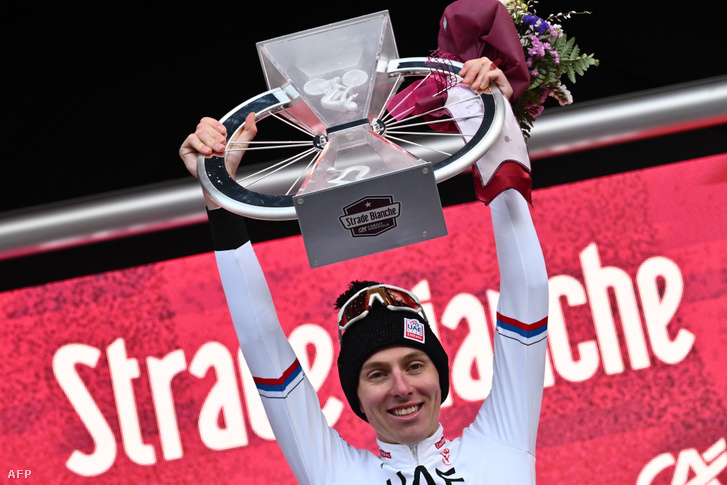 A szlovén Tadej Pogacar ünnepel a dobogón, miután megnyerte a 18. egynapos klasszikus "Strade Bianche" kerékpárversenyt Siena és Siena Toszkána között 2024. március 2-án