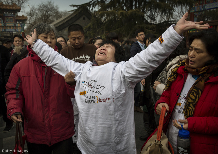 A Malaysia Airlines MH370-es járatának eltűnt utasának kínai rokona a Lama templom főkapuja előtt Pekingben, Kínában, 2015. március 8-án