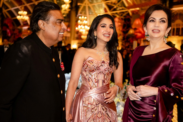 Az örömapa, Mukesh Ambani az épp a Versace ruháját viselő menyasszony, Radhika Merchant és a leendő anyós, Nita Ambani társaságában.