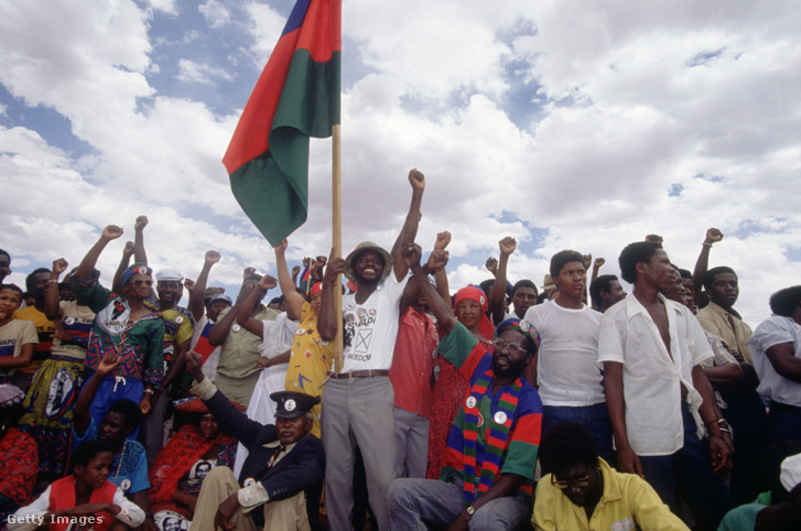 Namíbiaiak egy csoportja zászlót lobogtat és öklét emeli a Délnyugat-Afrikai Népi Szervezet (SWAPO) politikai gyűlésén, a függetlenségi folyamat kezdetét jelző országos választások előtt