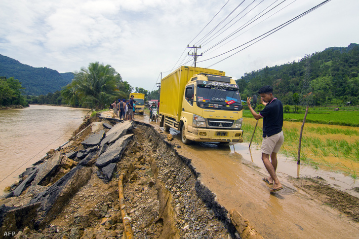 Egy férfi egy teherautót irányít egy megsérült úton Nyugat-Szumátrában, miután a tartományt heves esőzések sújtották, 2024. március 9-én