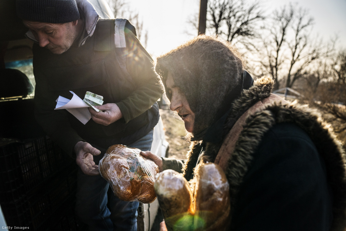 Egy polgárnak vizet és kenyeret adnak önkéntesek, miközben az orosz–ukrán háború folytatódik a Donyecki területen, Ukrajnában 2024. március 8-án