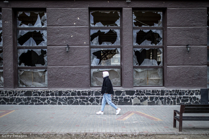 Egy férfi sétál a betört ablakok mellett, miközben az orosz–ukrán háború a harmadik évébe lép Herszonban, Ukrajnában 2024. március 7-én
