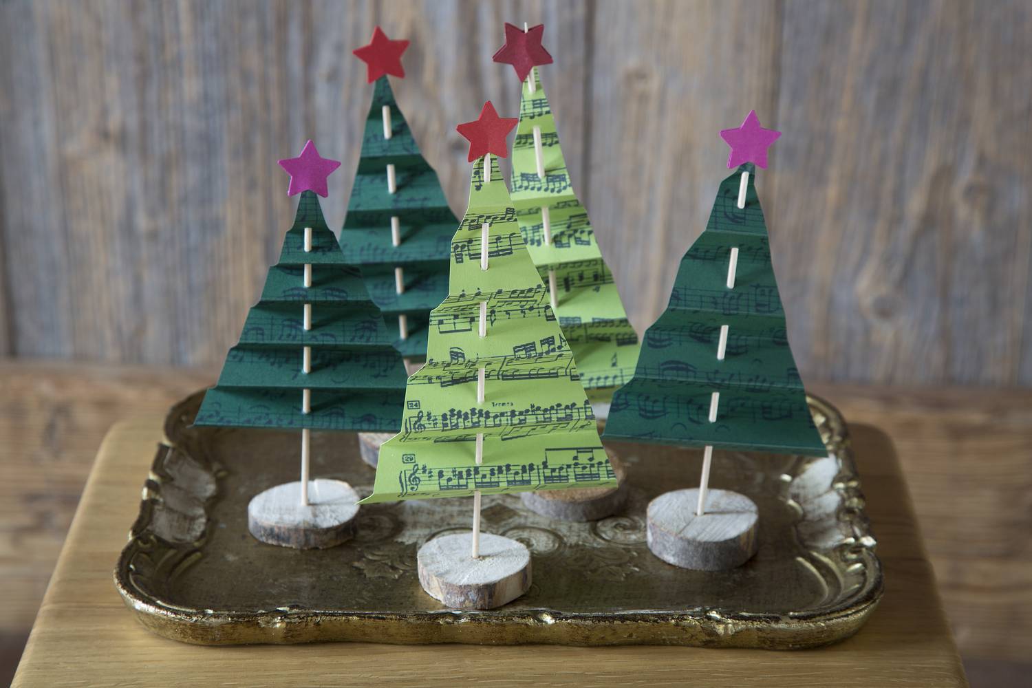 Ezt a fenyődíszt pofonegyszerű elkészíteni, a háromszög formájúra vágott papírt csak harmonikaszerűen fel kell hajtogatni, majd beletűzni a pálcikát.
