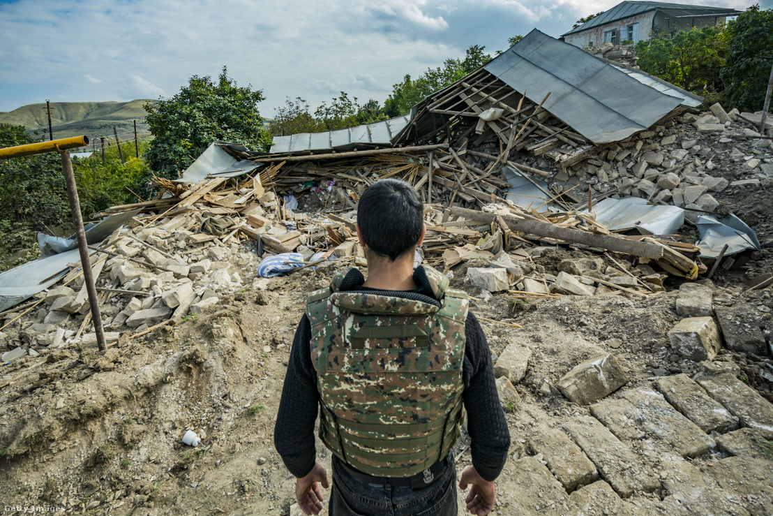 Egy milicista nézi egy azeri rakéta által lerombolt ház romjait Martuni faluban, a Hegyi Karabah és Azerbajdzsán hadserege közötti összecsapások során 2020. október 11-én