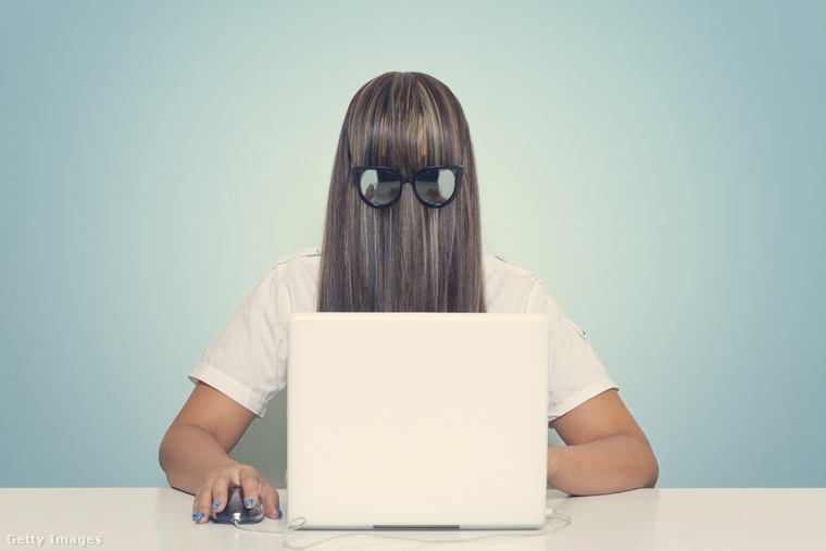 Illusztráció: Nő egy laptop előtt, arcába fésült hajjal, napszemüveggel. (Fotó: Francesco Carta fotografo / Getty Images Hungary)