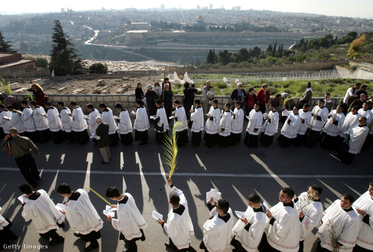 Katolikus papok és kóristák vesznek részt a hagyományos pálmavasárnapi körmeneten az Olajfák hegyén a Nagyhét kezdetén 2005. március 20-án Jeruzsálem óvárosában