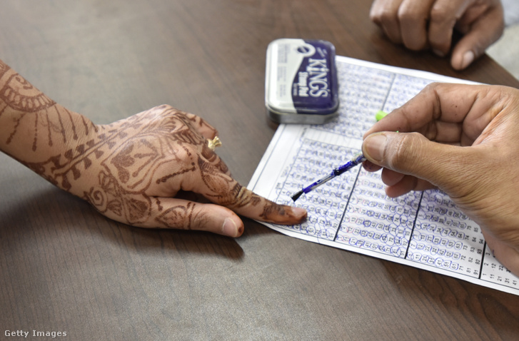 Egy tisztviselő kitörölhetetlen tintát ken egy szavazó ujjára a Modern Delhi Public Schoolban, Nagy-Faridabadban, Indiában, 2019. október 21-én