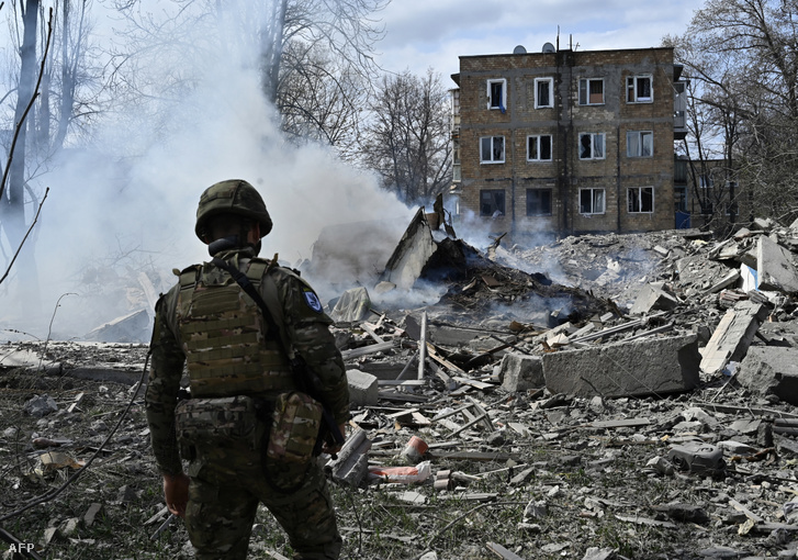 Az ukrán Fehér Angyalok különleges rendőri csoport egyik tagja egy légicsapást követően lerombolt lakóépület törmelékeit nézi a frontvonalban lévő Avdijivka donyecki régióbeli városban 2023. április 10-én