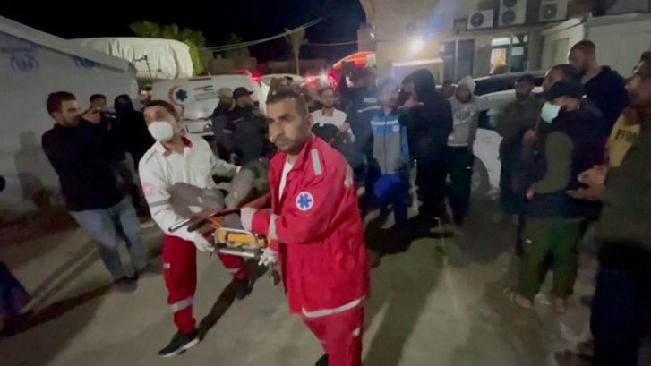A World Central Kitchen (WCK) egyik dolgozójának holttestét szállítják a mentősök Deir al-Balahban 2024. április 1-én