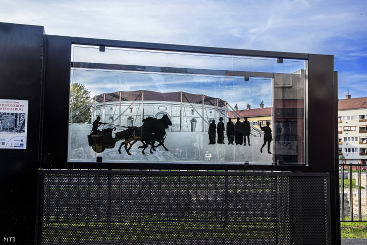 Áttetsző üvegfestményen szimbolizálják az egykori Aquincum katonai (katonavárosi) amfiteátrumának életét Óbudán – amely Budapest városrésze a III. kerületben –, a Nagyszombat utca – Pacsirtamező utca – Viador utca – Szőlő utca által határolt területen fekszik, 2022. október 7-én