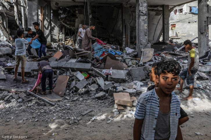 Palesztinok megvizsgálnak egy házat, amely egy izraeli légicsapás következtében megsemmisült