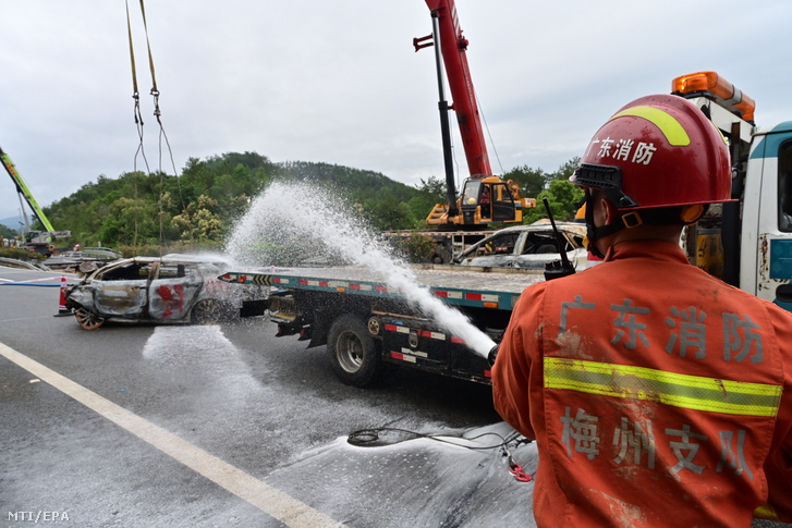 Tűzoltó dolgozik egy gyorsforgalmi út megrongálódott szakaszánál Kuangtung tartományban 2024. május 1-jén