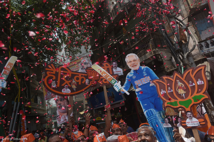 A BJP (Bharatiya Janata Party) támogatói Narendra Modi indiai miniszterelnök kivágott képét viszik, és ünneplik a Lok Sabha választási eredmény napját Varanasziban, Indiában 2024. június 4-én