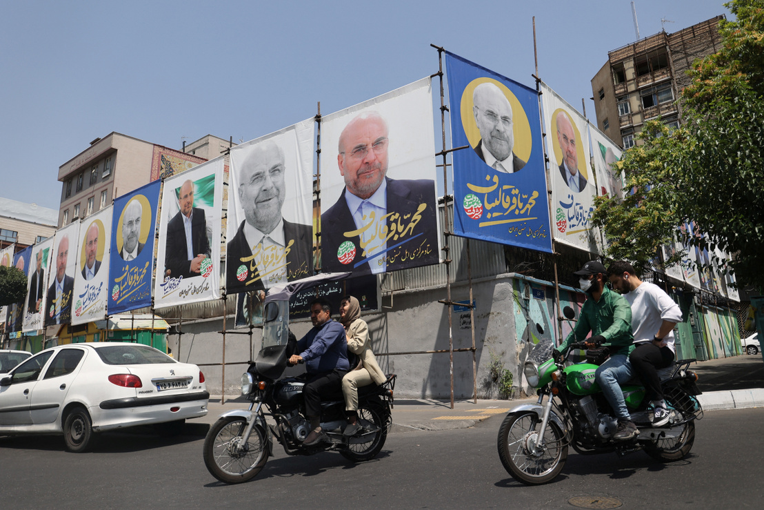Emberek haladnak el Mohamed Báqer Qalibáf elnökjelölt transzparensei mellett Teheránban, Iránban 2024. június 22-én