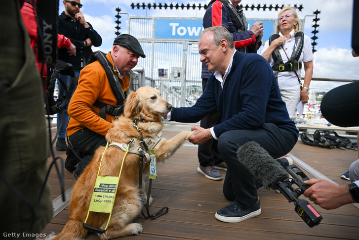 Ed Davey (j), a Liberális Demokraták vezetője találkozik Steve Darling képviselőjelölttel (b) és vakvezető kutyájával, Jennie-vel 2024. június 11-én Torquayben, Angliában