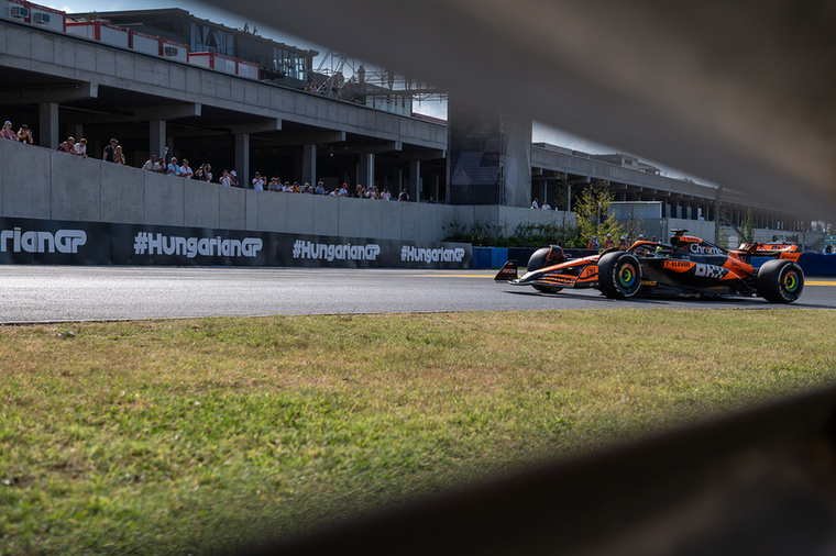 Oscar Piastri a Hungaroring 13-as kanyarjának korlátján keresztül.