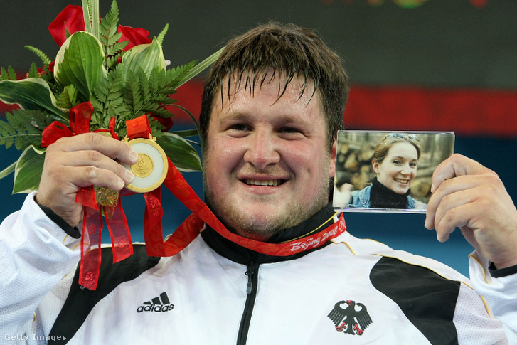 A német Matthias Steiner ünnepli az aranyérmet a férfi 105 kg-os súlyemelőcsoportban, miközben kezében néhai felesége, Suzanne Steiner fényképét tartja a 2008-as pekingi olimpiai játékok 11. napján, 2008. augusztus 19-én Pekingben, Kínában