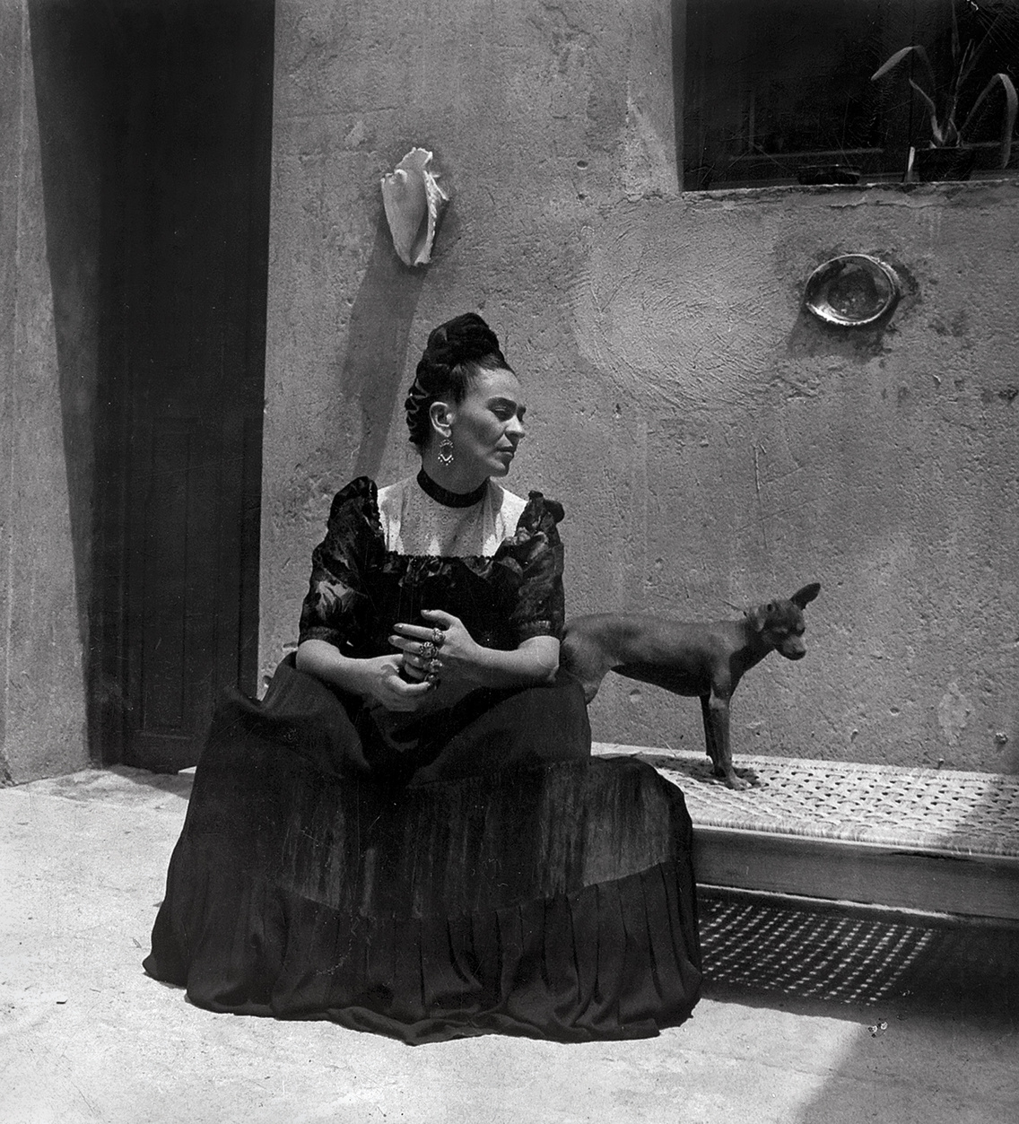 Frida Kahlo mexikói meztelen kutyával a Kék Ház előtt (1944 körül)