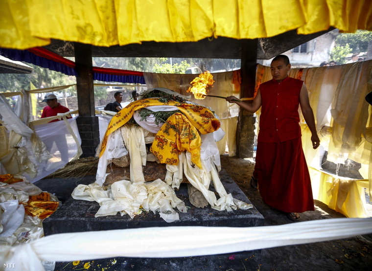 Az egyik serpa halottégető máglyáját gyújtja meg egy szerzetes Katmanduban