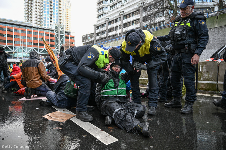 Biztonsági erők avatkoznak be az Extinction Rebellion több száz aktivistájának tüntetésébe az A12-es autópályán Hágában, Hollandiában 2025. január 11-én