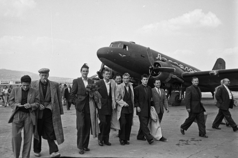 Budapest, XI. Budaörsi repülőtér, a szovjet vendégszereplésről hazaérkező Vasas labdarúgó csapatának fogadása. Virágcsokorral Szilágyi I Gyula, tőle jobbra a negyedik Kotász Antal. A háttérben egy Liszunov Li-2 típusú repülőgép