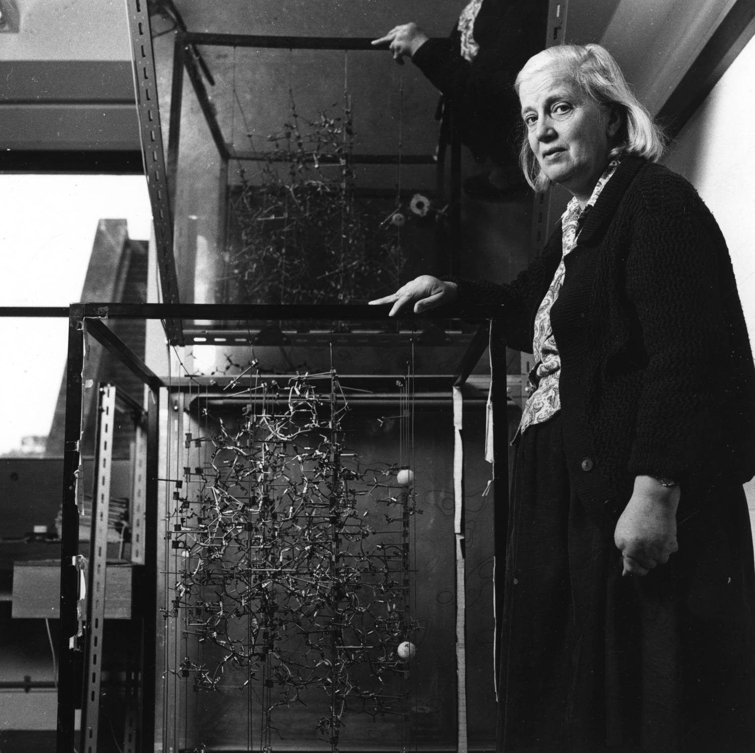Dorothy Hodgkin a fehérje molekulaszerkezetének modellje mellett.