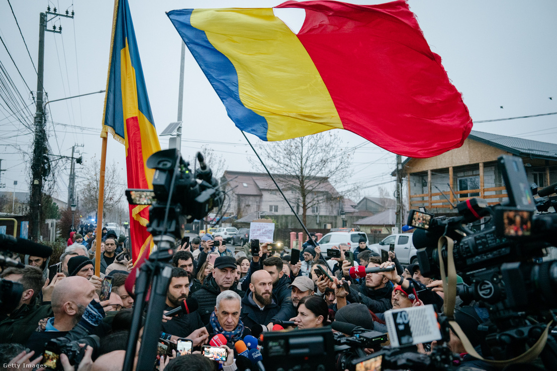 Calin Georgescu elnökjelölt támogatóival és a médiával egy lezárt szavazóhelyiség előtt 2024. december 8-án