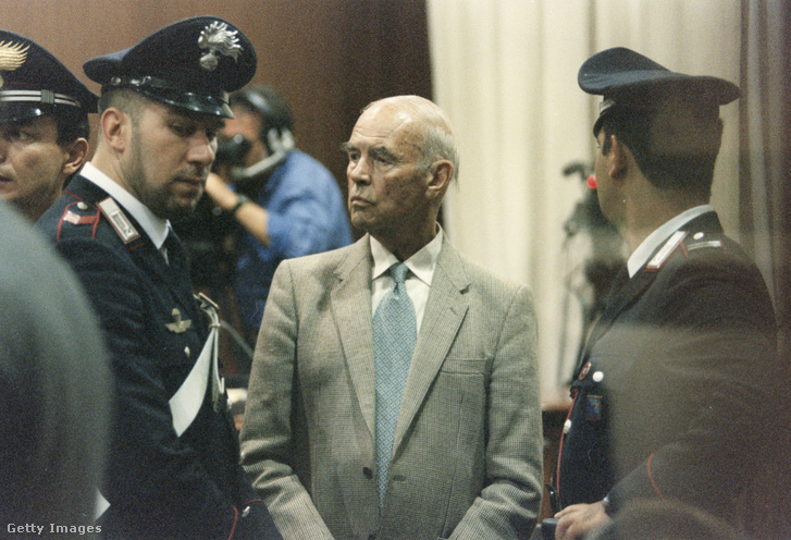 Erich Priebke volt SS-százados, római tömegmészáros rendőrökkel körülvéve a háborús bűnökkel vádolt tárgyalásán Rómában 1997. májusában