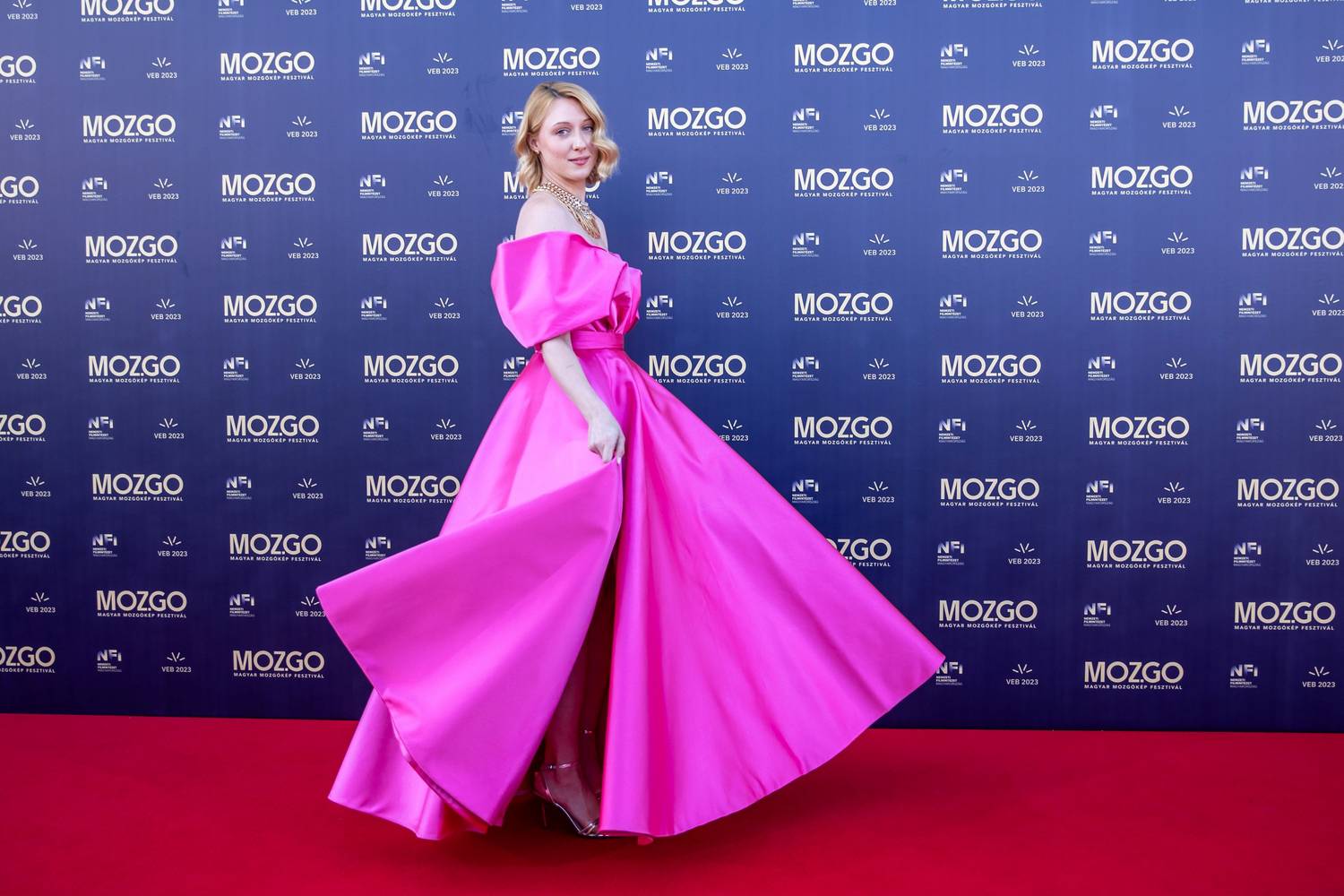 A kissé strukturált anyag karakteres sziluettet kölcsönzött a darabnak, míg az élénk árnyalat és az aszimmetrikus vállmegoldás modern eleganciával látta el. Az egyszínű darabot hangsúlyos nyaklánccal dobta fel, szőke haját pedig laza hullámokba sütötték be.