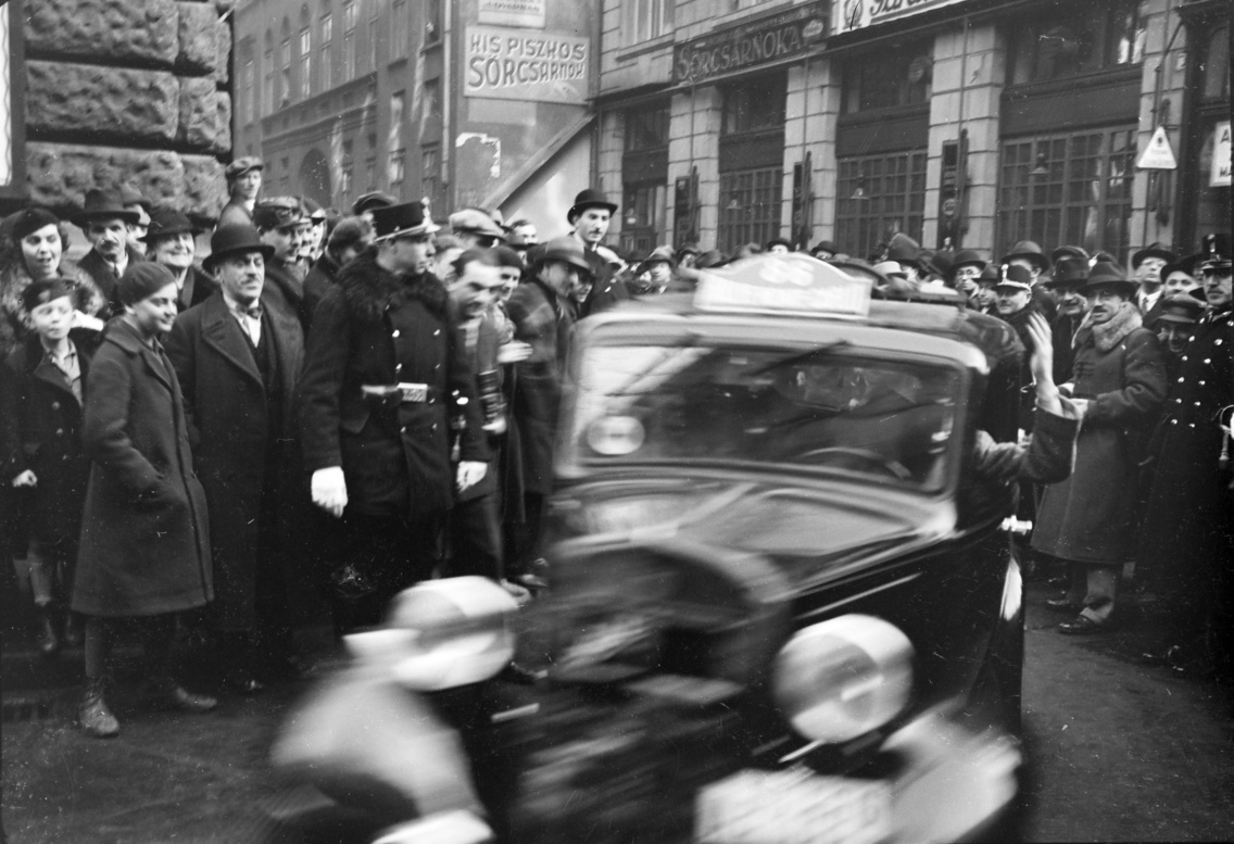 A Curia utca és Veres Pálné utca kereszteződése, Kozma Endre és Martinek István, a kis kategória későbbi győzteseinek Fiat Balilla típusú gépjárműve. A felvétel a monte-carló-i csillagtúra budapesti átvonulásakor készült, 1936-ban