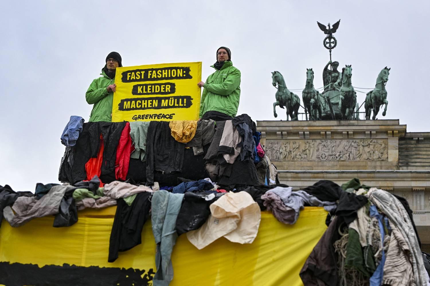 2024. február 5., Berlin: „Fast fashion: clothes make garbage!” (A fast fashion ruhák szemetet termelnek!) szlogen alatt a Greenpeace aktivistái a Brandenburgi kapu előtt tüntetnek a fast fashion ruhák által okozott környezetszennyezés ellen.