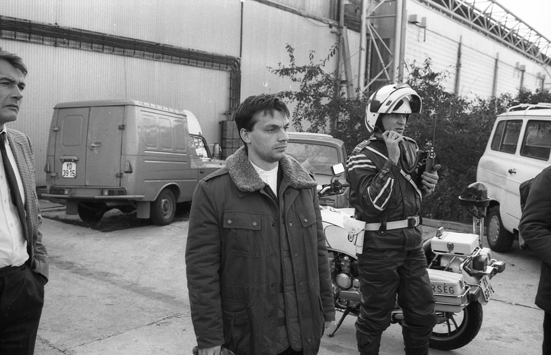 Balra Gellért Kis Gábor újságíró, filmes, országgyűlési képviselő. Középen Orbán Viktor későbbi miniszterelnök, aki helikopterrel megy az 1956. október 26-i mosonmagyaróvári sortűz évfordulóján tartandó megemlékezésre, 1990