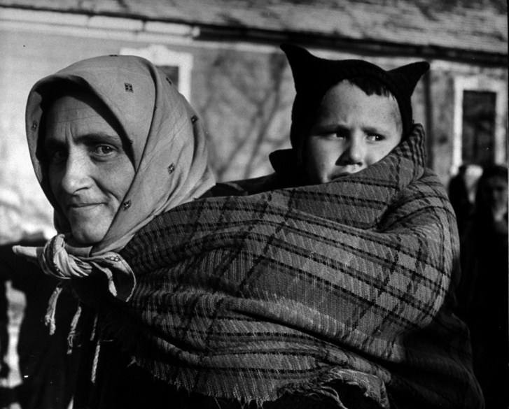Német anya gyermekét a hátán viszi 1946. februárjában
