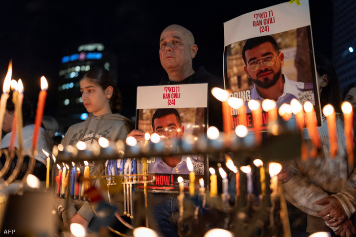 Izraeliek Ran Gvili arcát ábrázoló plakátokat tartanak a kezükben Tel-Avivban, 2025. december 21-én