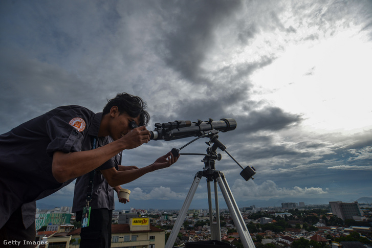 Egy muszlim férfi távcsővel figyeli a Hold változó fázisait 2026. február 17-én