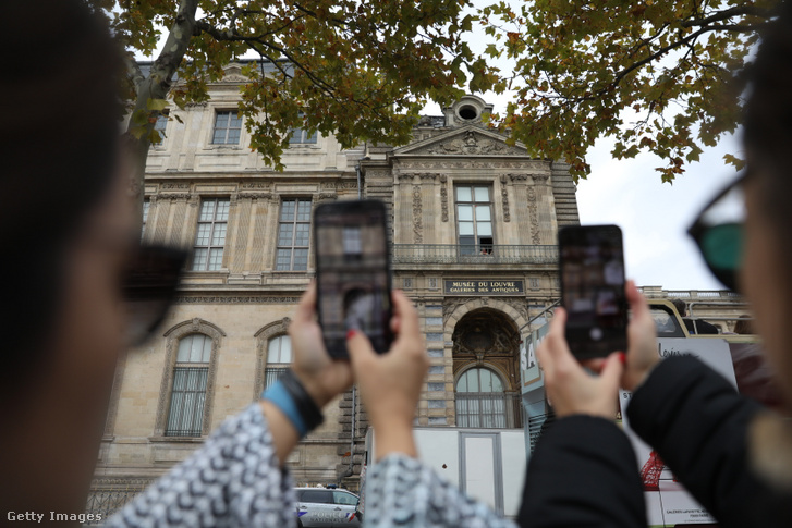 Áttekintő kép a Louvre Múzeumról egy nappal azután, hogy tolvajok nyolc felbecsülhetetlen értékű királyi ékszert loptak el a múzeumból, miközben a turisták a bezárás ellenére továbbra is látogatják a területet, hogy fényképeket készítsenek, Párizsban 2025. október 20-án