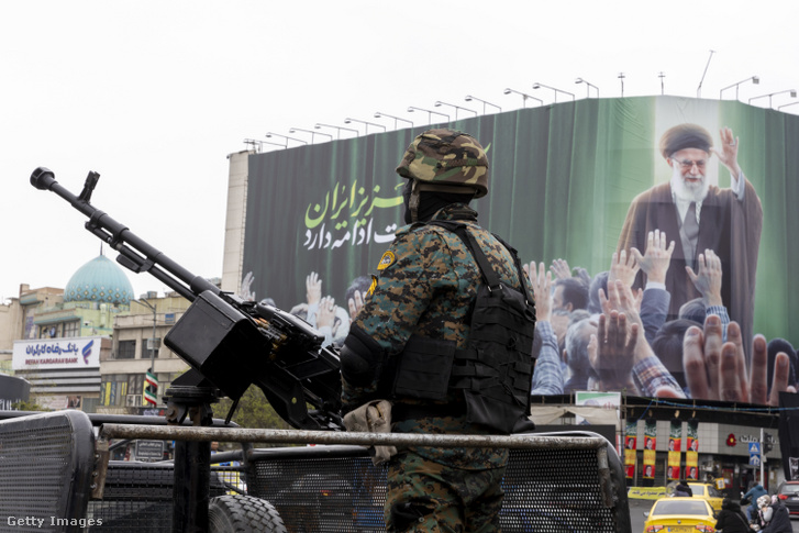 Egy rendőr őrködik Ali Hámeneit ábrázoló plakát előtt Teheránban 2026. március 10-én