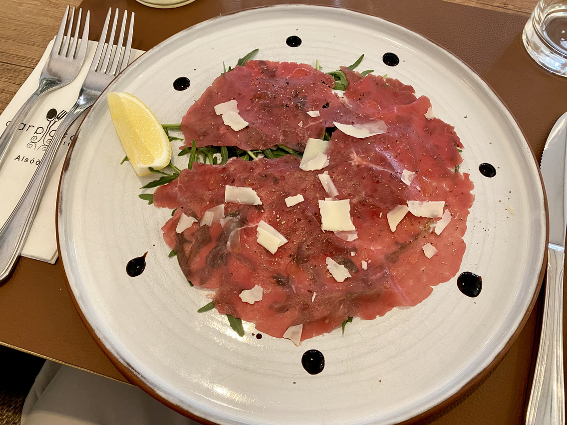 Miközben Zsolt mesélni kezd, az első fogás is érkezik: bélszíncarpaccio olívaolajjal, rukkolával és Grana Padanóval