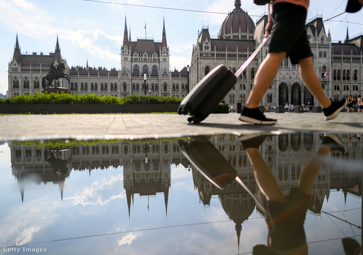 Egy férfi bőrönddel sétál a Kossuth Lajos téren Budapesten 2021. június 20-án