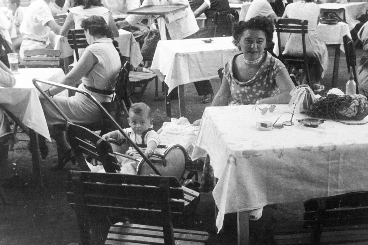 Babakocsi, hálós szatyor és szódásüveg a kerthelyiségben. (1950.)