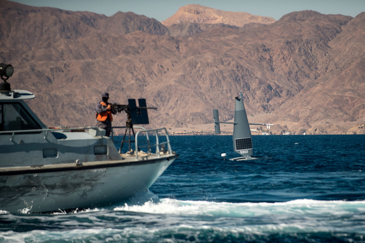 Egy Saildrone Explorer pilóta nélküli felszíni drón elhalad a Jordán Királyi Haditengerészet egyik járőrhajója mellett 2022. február 9-én