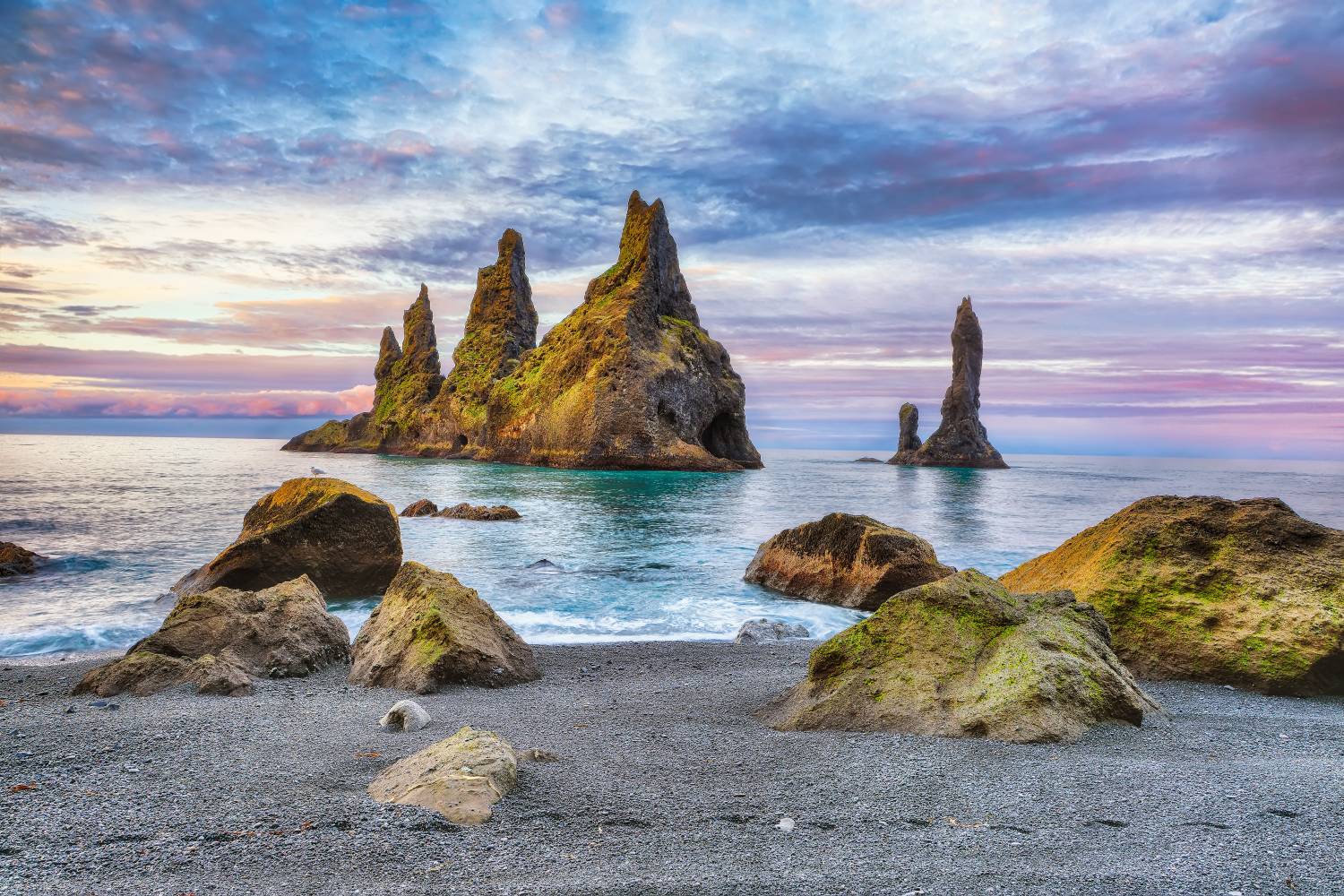 Reynisdrangar bazaltoszlopok Izlandon. Az izlandi legenda szerint a tengerből kiemelkedő sziklaalakzatok egykor trollok voltak, akiket a felkelő nap sugarai változtattak kővé, miközben egy hajót próbáltak a partra vonszolni.