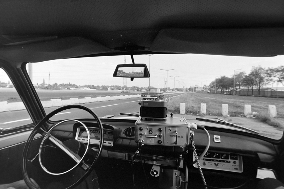 A sebességellenőrző rendőrautó a Gyömrői út 156. számnál áll, balra mellette a Ferihegyi repülőtérre vezető út, 1977