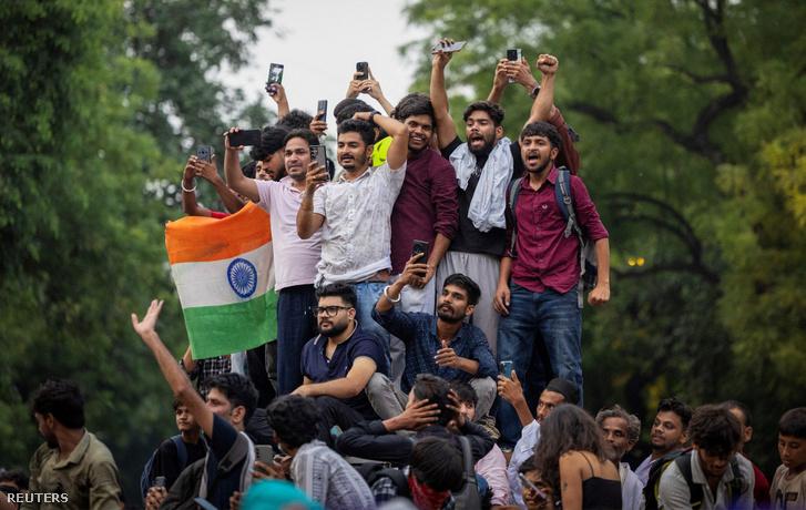 Az indiai Cockroach Janta Party (CJP) támogatói ünnepelnek, miután Dharmendra Pradhan indiai oktatási miniszter lemondott, miután napokig tartó tiltakozások követelték a távozását a Nemzeti Jogosultsági és Felvételi Teszt (NEET) vizsgafeladatainak kiszivárgása miatt, Újdelhiben, Indiában 2026. július 25-én