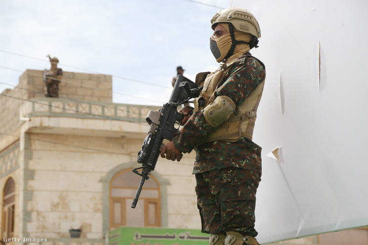 A houthi biztonsági erők tagjai őrt állnak, miközben a jemeni houthi mozgalom támogatói részt vesznek egy tüntetésen, amelyet a Szaúd-Arábia vezette koalíció által 2026. március 26-án indított katonai hadjárat 11. évfordulójának megünneplésére rendeztek Sana'ában, Jemenben